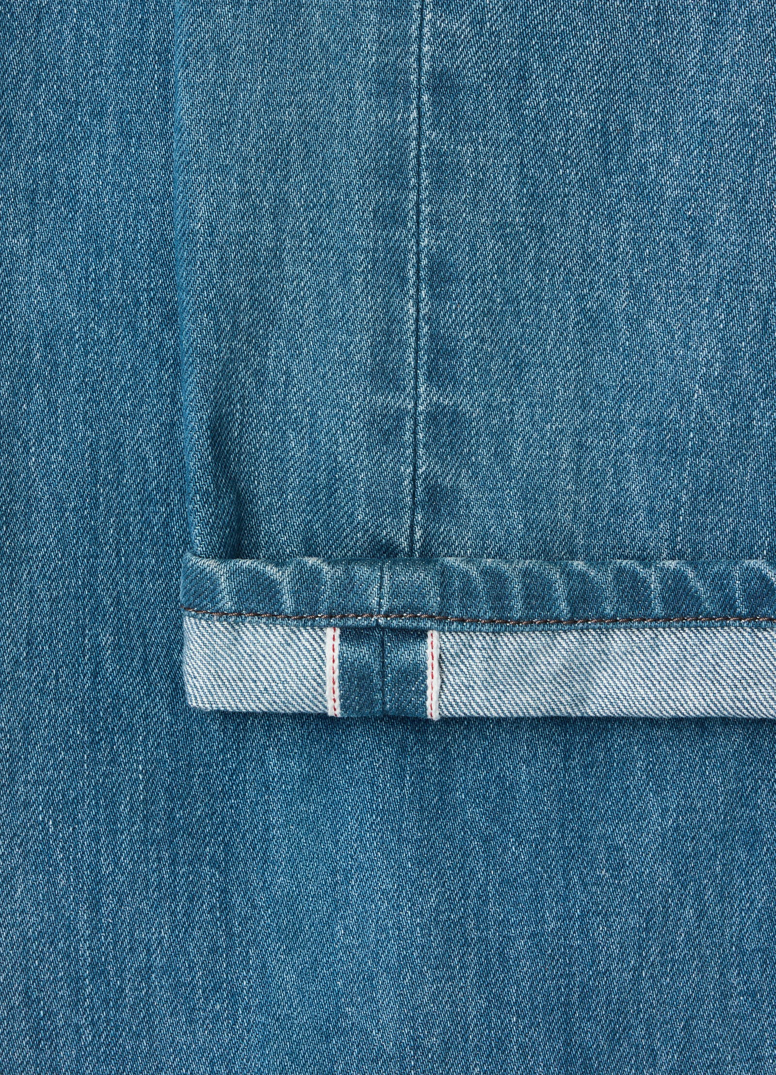 Straight five-pocket indigo selvedge denim pants lemaire close-up of cuff detail worn by a model