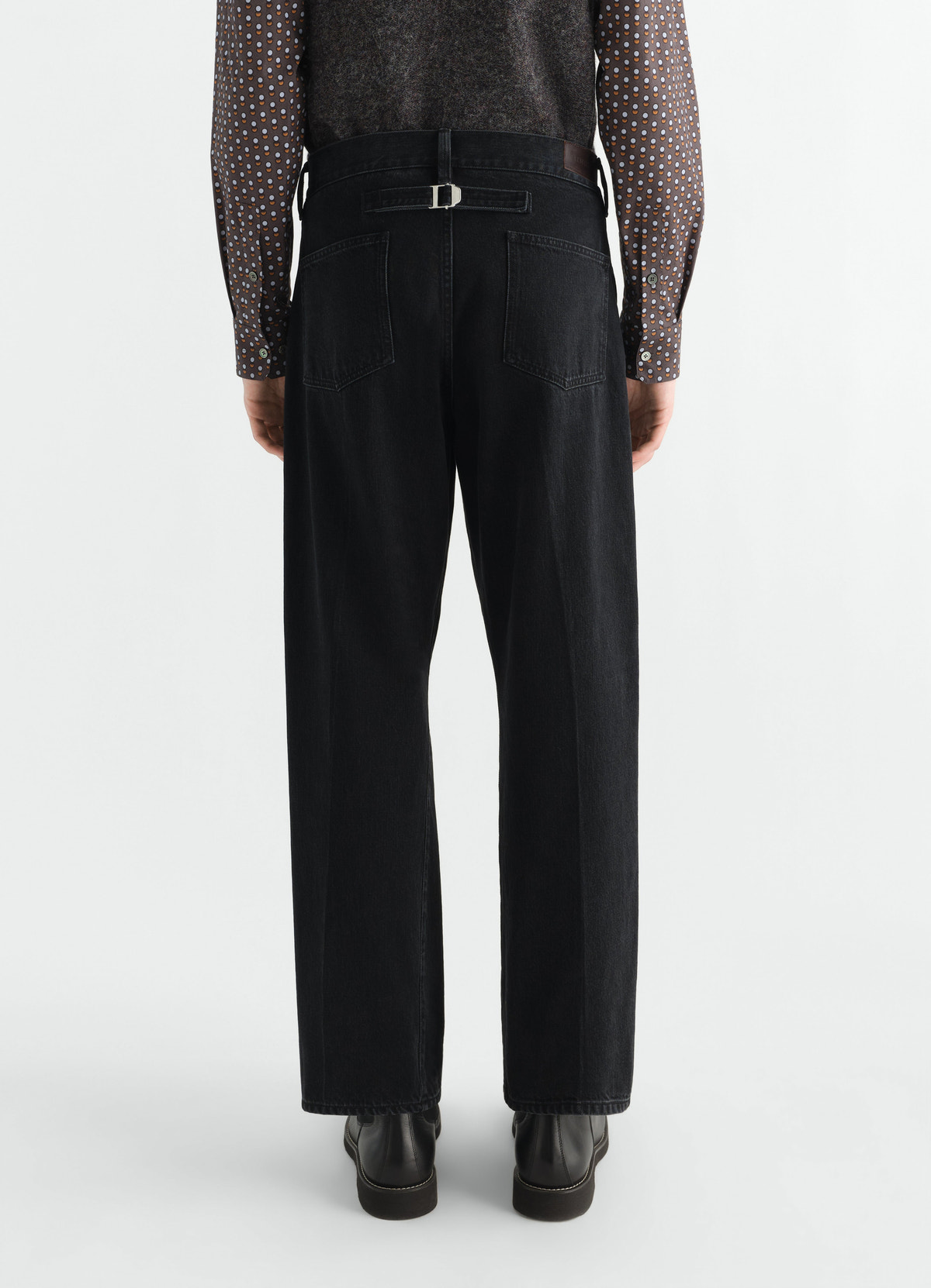 Straight black washed selvedge denim pants by lemaire with back pockets and buckle detail, worn by model back view