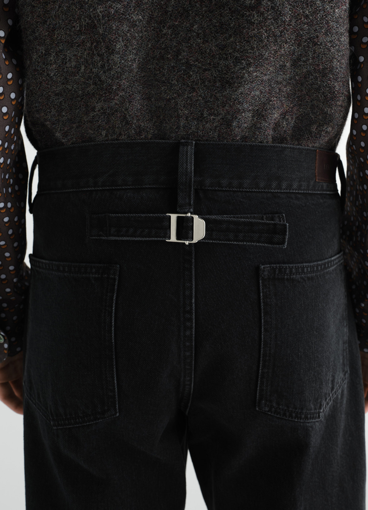 Straight black washed selvedge denim pants with silver buckle detail lemaire worn by model back view
