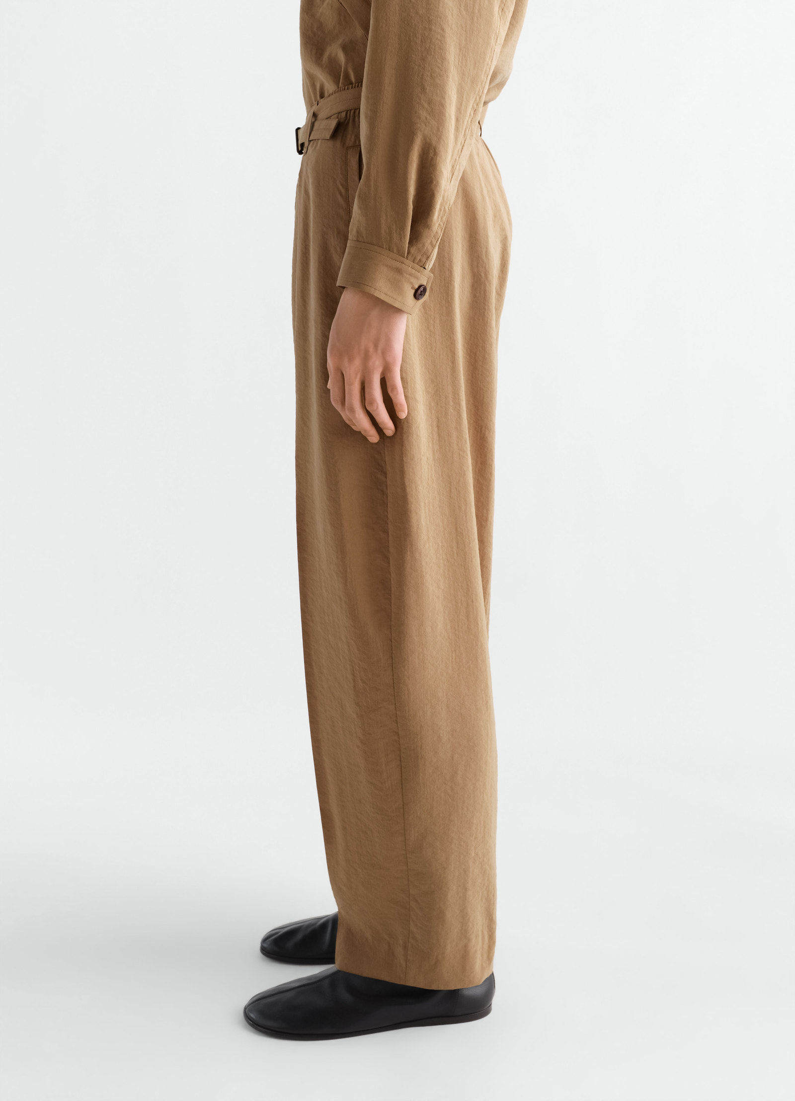 Belted relaxed dry silk pants in camel brown by lemaire worn by a model side view