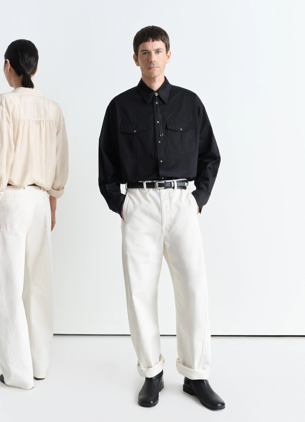 Lemaire Twisted Belted Pants in Garment Dyed Snow Heavy Denim, model shot, front view curved leg, mid-rise