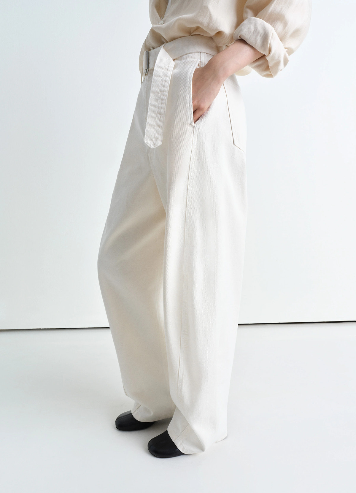 Lemaire twisted belted pants in garment dyed snow heavy denim, model shot, three-quarter view wide leg, relaxed fit