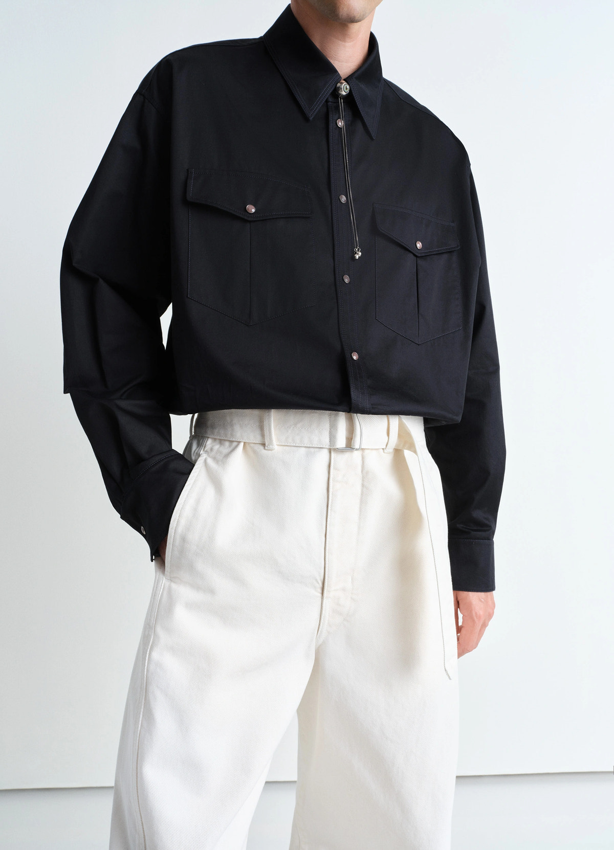 Lemaire twisted belted pants in garment dyed snow heavy denim, model shot, waist front view wide leg pleated design