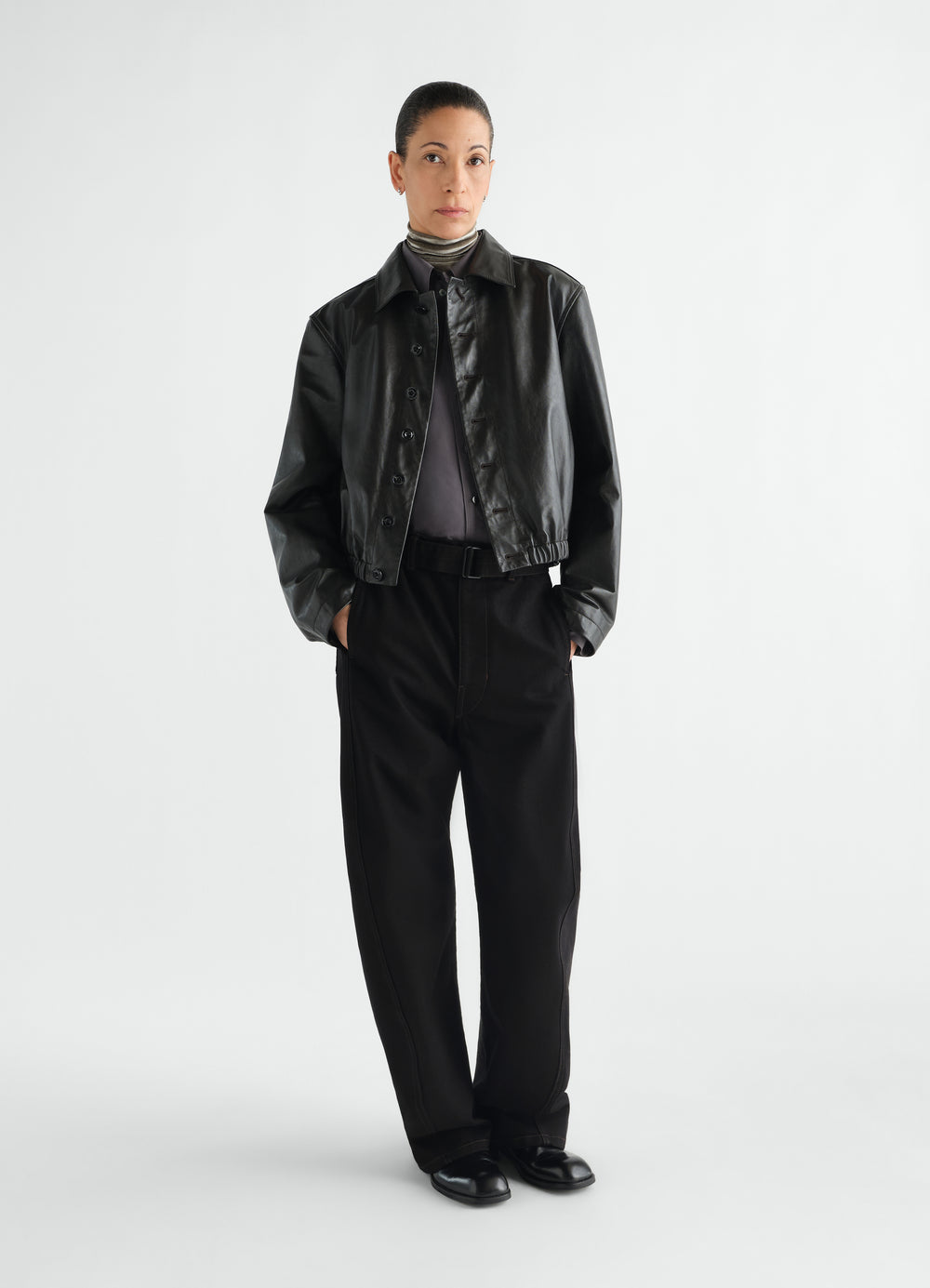 Twisted belted black denim pants worn by model front view styled look LEMAIRE