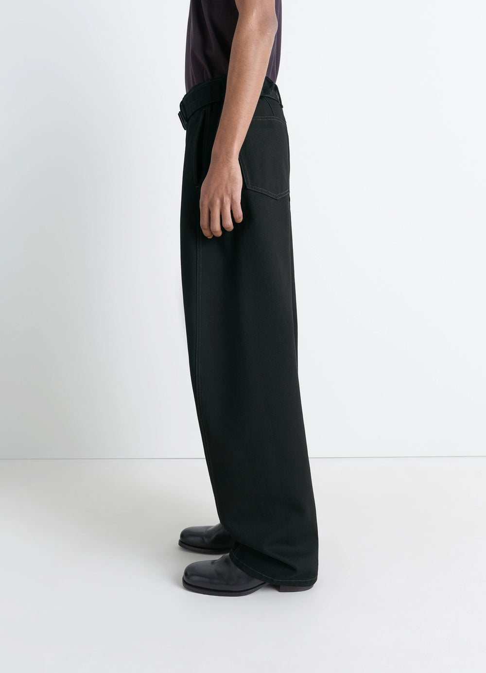 Lemaire Twisted Belted Pants in Deep Black Heavy Denim, model shot, side view wide leg with belt