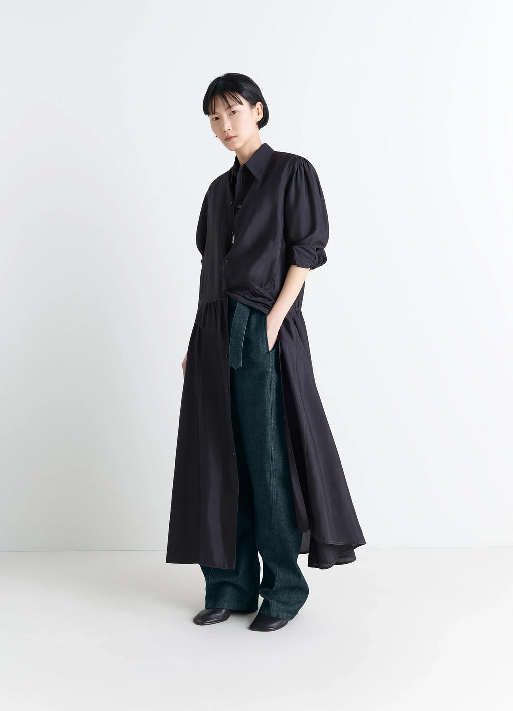 Lemaire Twisted Belted Pants in Deep Indigo Heavy Denim, model shot, side view loose fit worn with dress
