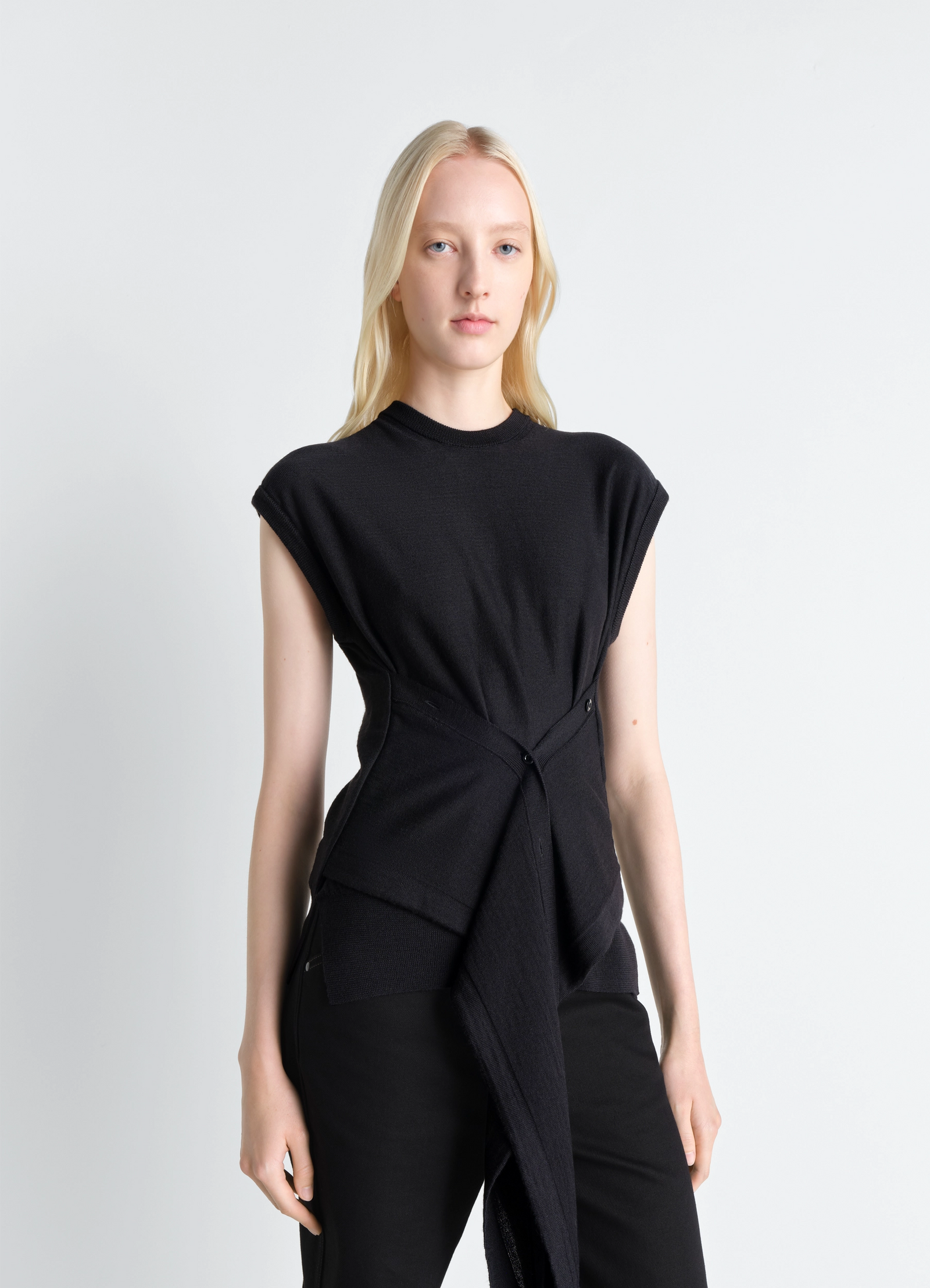 Sleeveless buttoned top in black merino blend, model shot, front view buttoned side panels