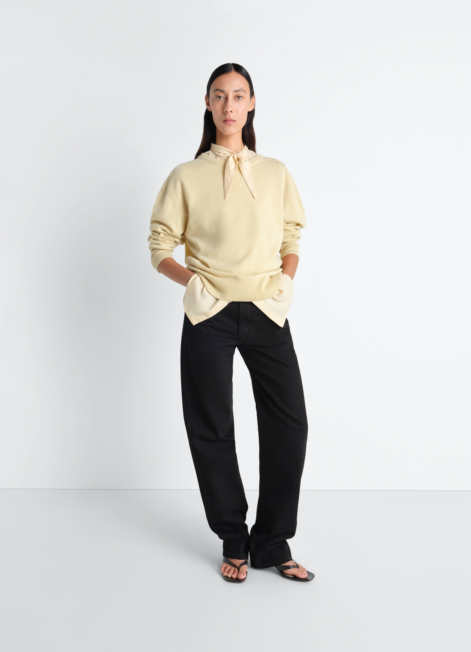 Lemaire crew neck sweater in cashmere wool, model shot, three-quarter view tucked-in styling