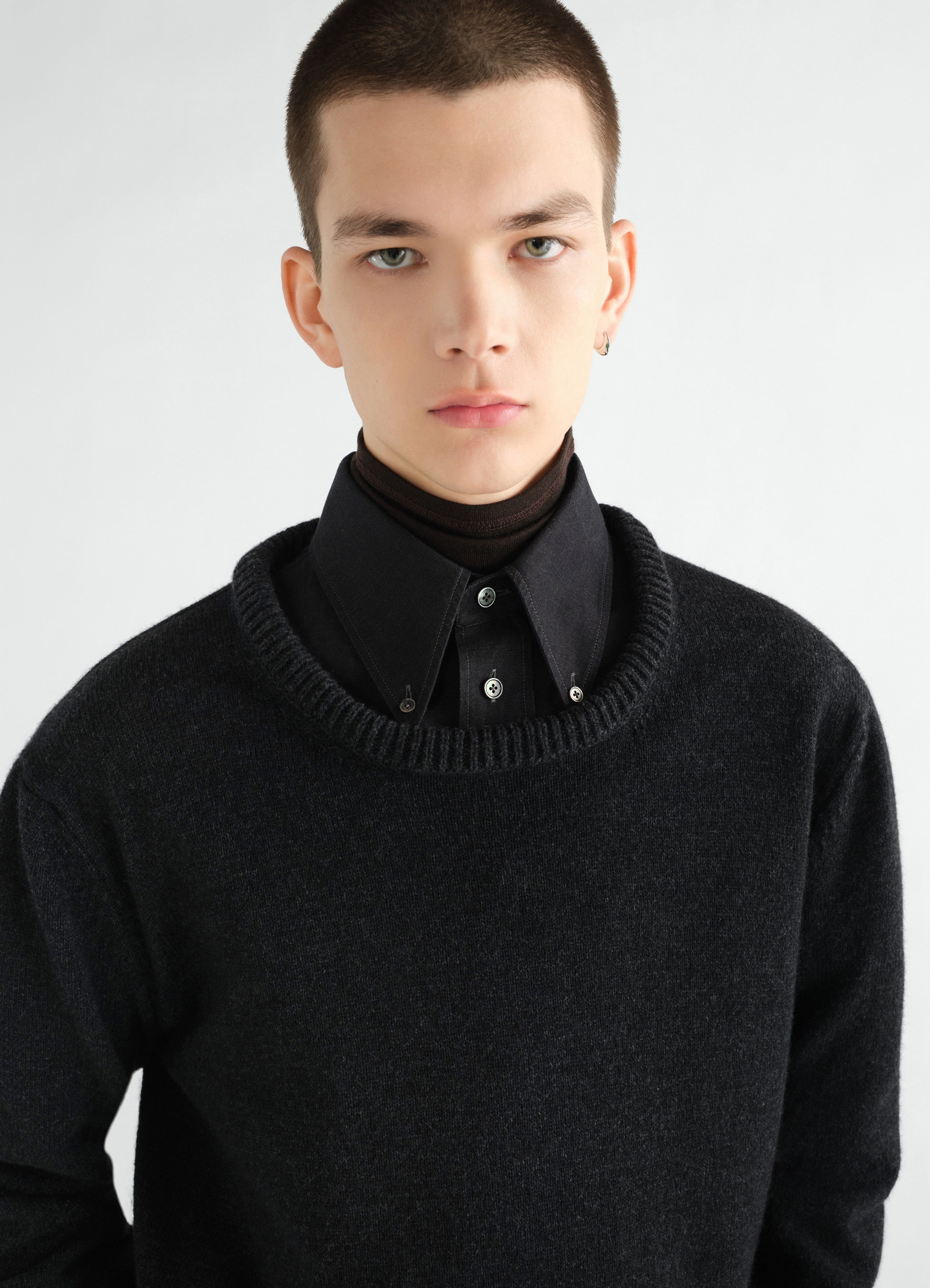 Crew-neck black alpaca wool blend sweater by lemaire worn by model with black shirt collar detail front view