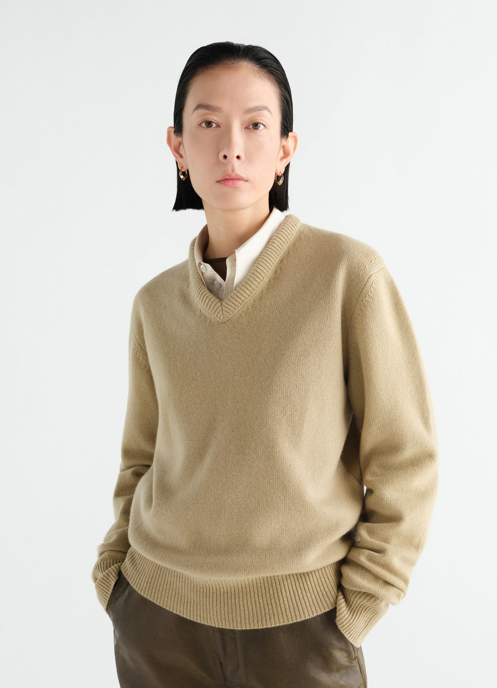 Pull à encolure V en cachemire, coloris beige, porté par un mannequin, vue de face
