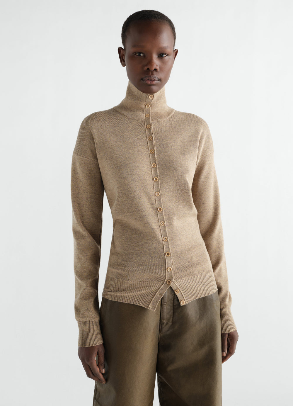 Buttoned beige fine wool top with high collar worn by model LEMAIRE front view