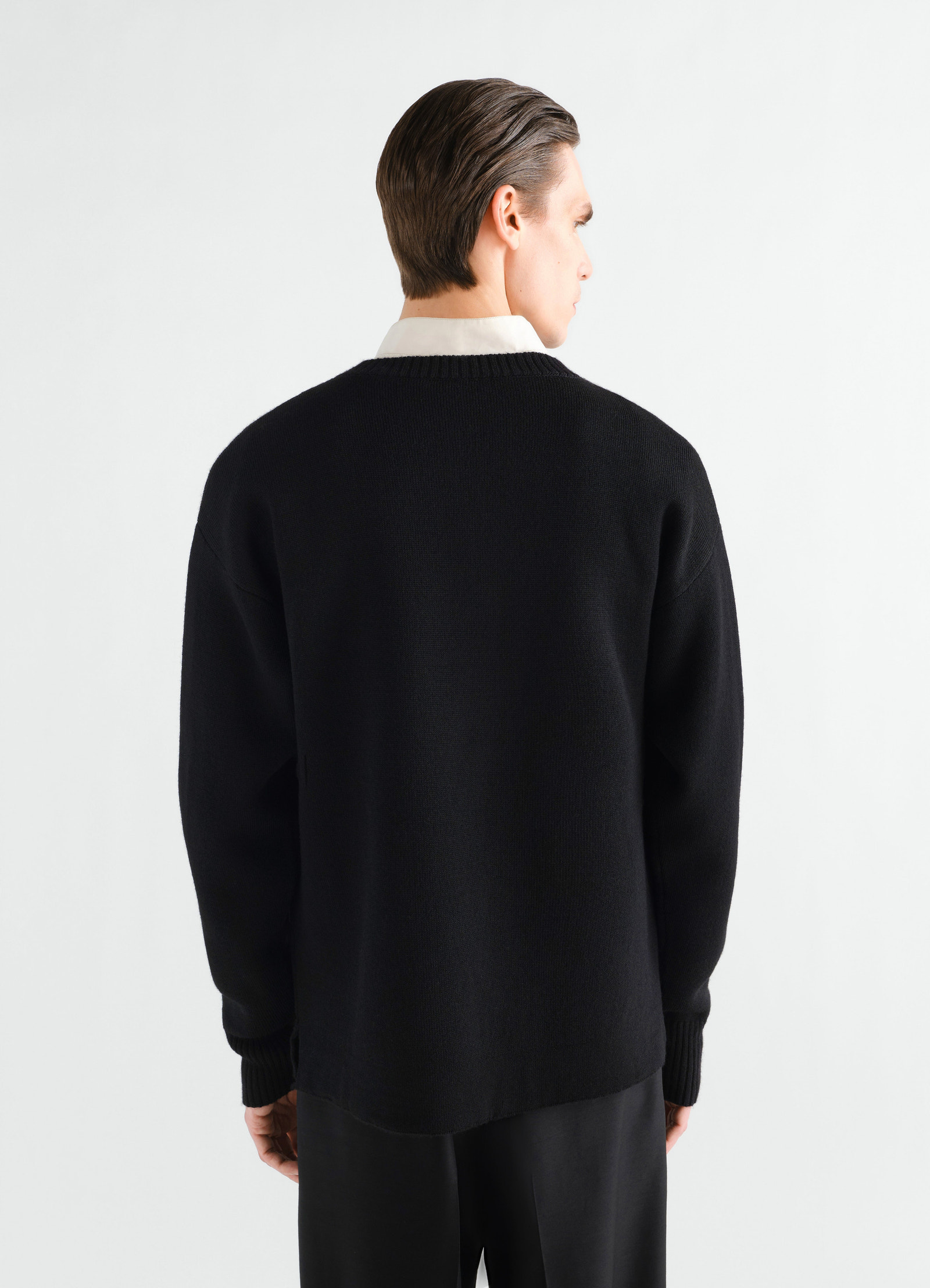 Boat-neck black double-face virgin wool sweater by lemaire worn by a model back view on white background