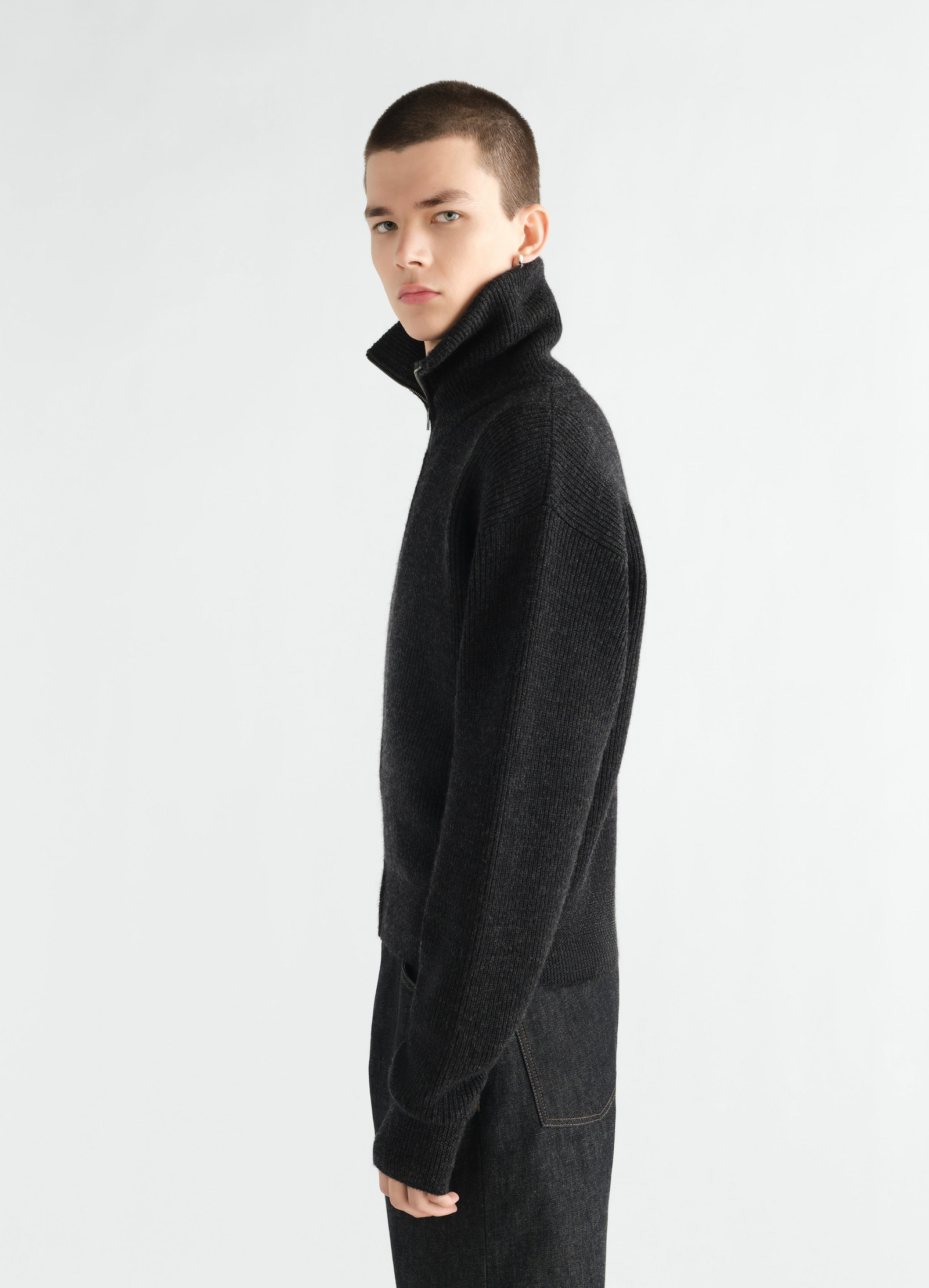Cardigan zippé en laine vierge, coloris noir, porté par un mannequin, vue de profil, fermeture zippée visible, col visible, manches visibles