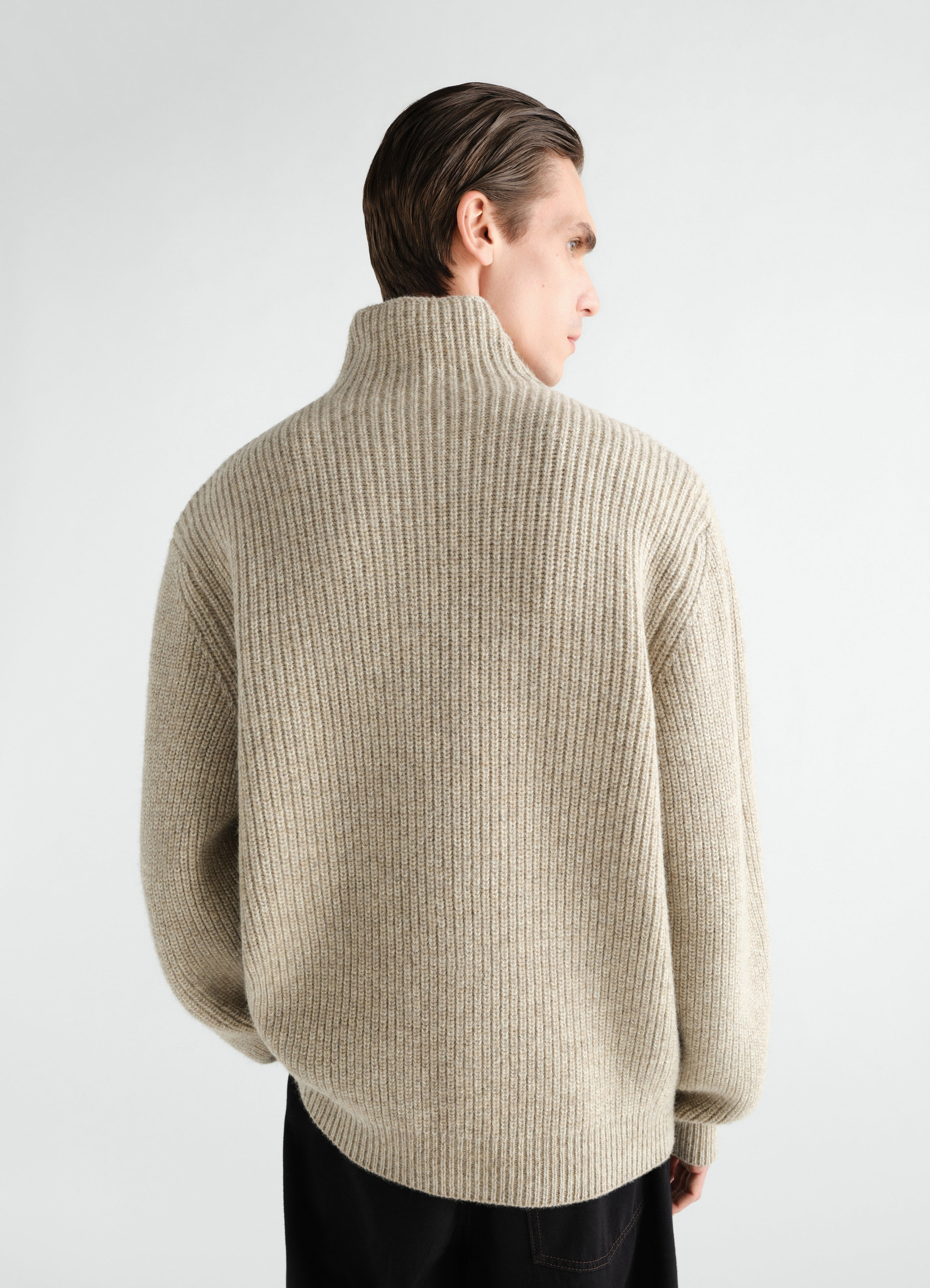 High neck beige yak alpaca sweater by lemaire worn by a model back view with ribbed texture