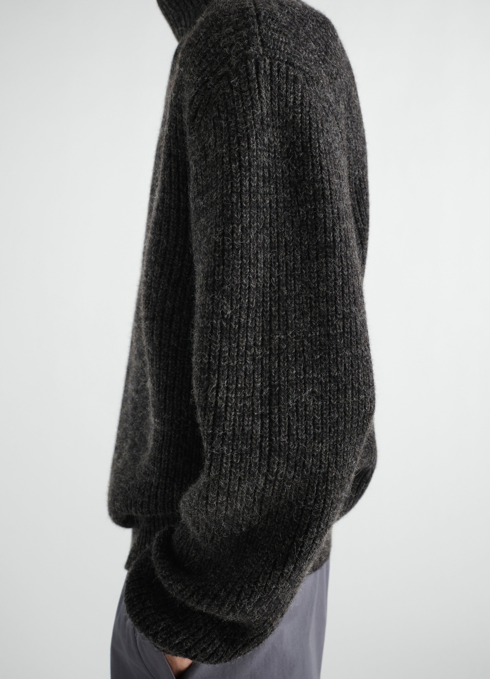 High neck dark grey yak alpaca sweater by lemaire worn by a model side view with textured knit and long sleeves