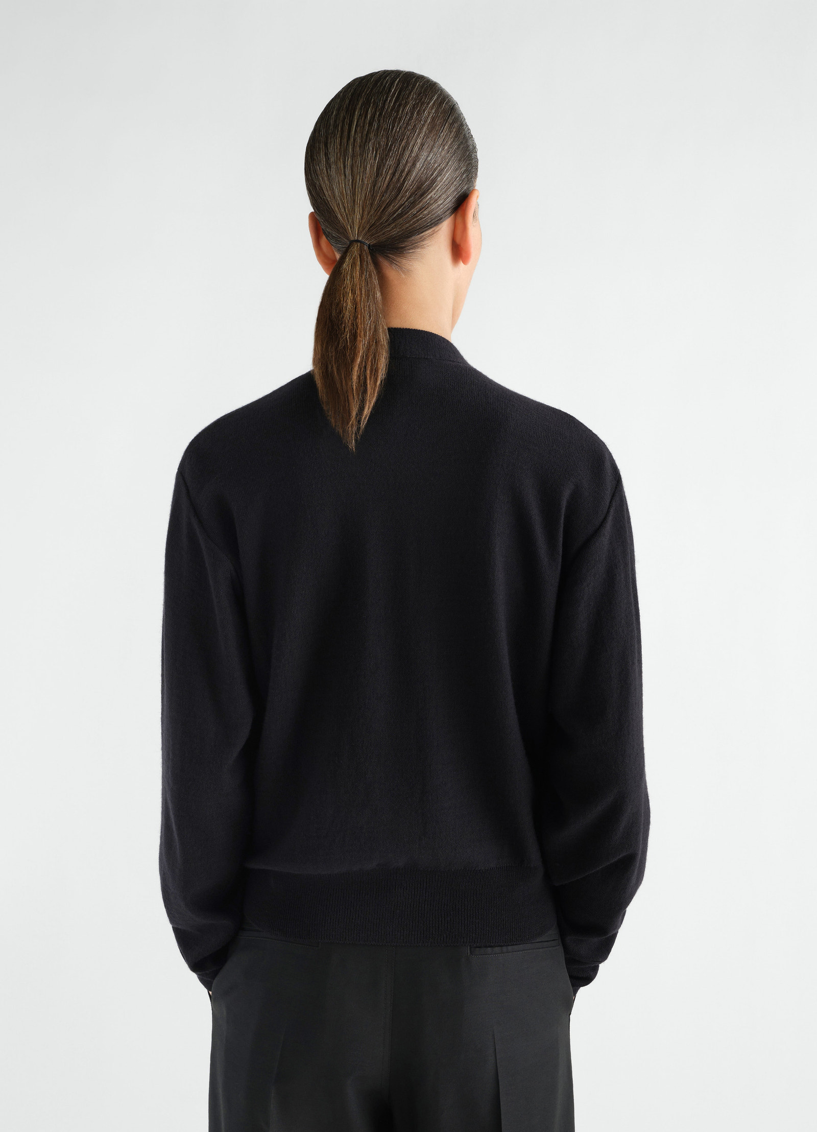 Black merino wool blend trompe-l’œil cardigan lemaire worn by a model back view with ribbed hem and cuffs