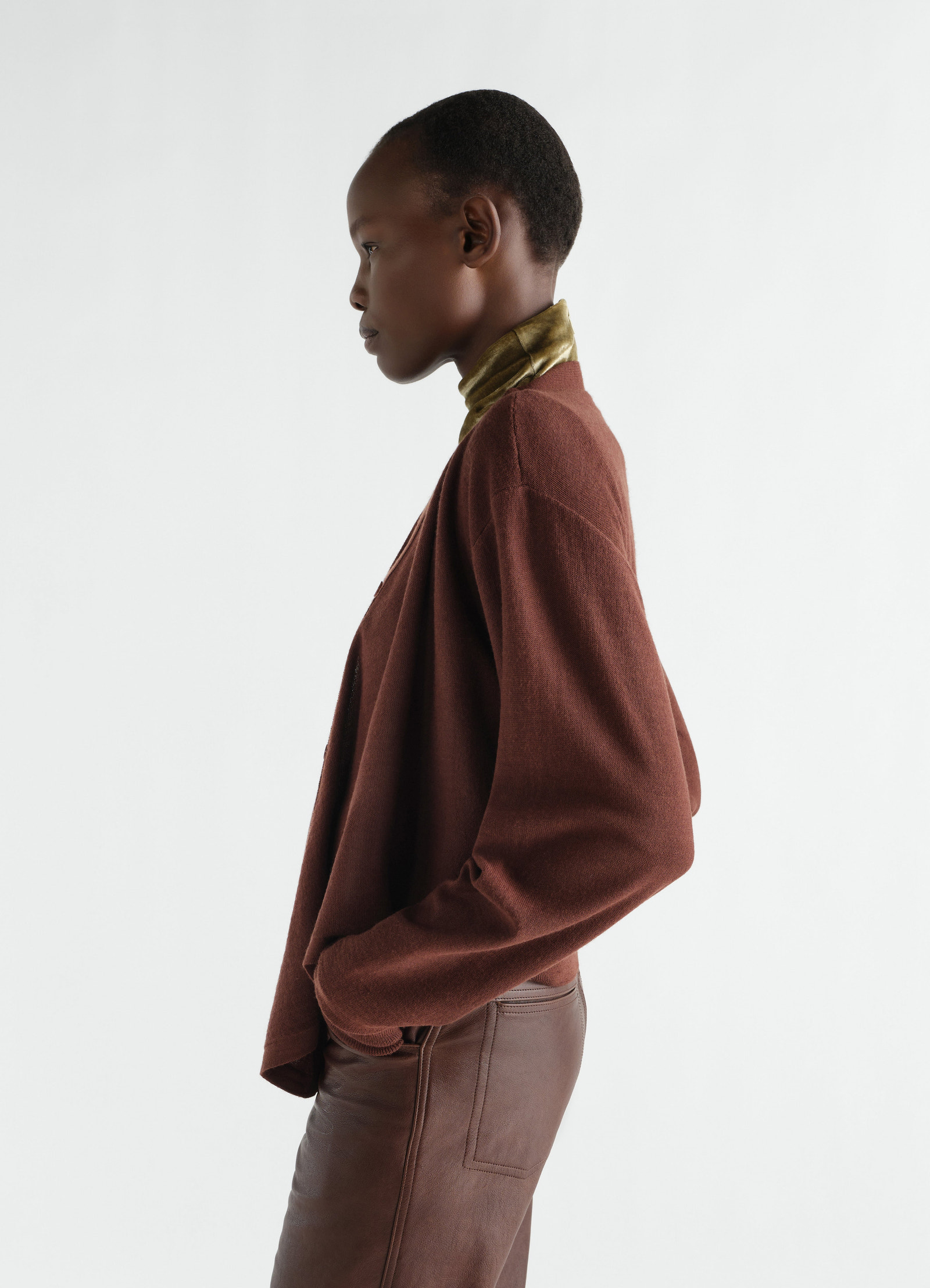 Lemaire brown merino wool blend trompe-l’œil cardigan worn by model side view with leather pants and green turtleneck