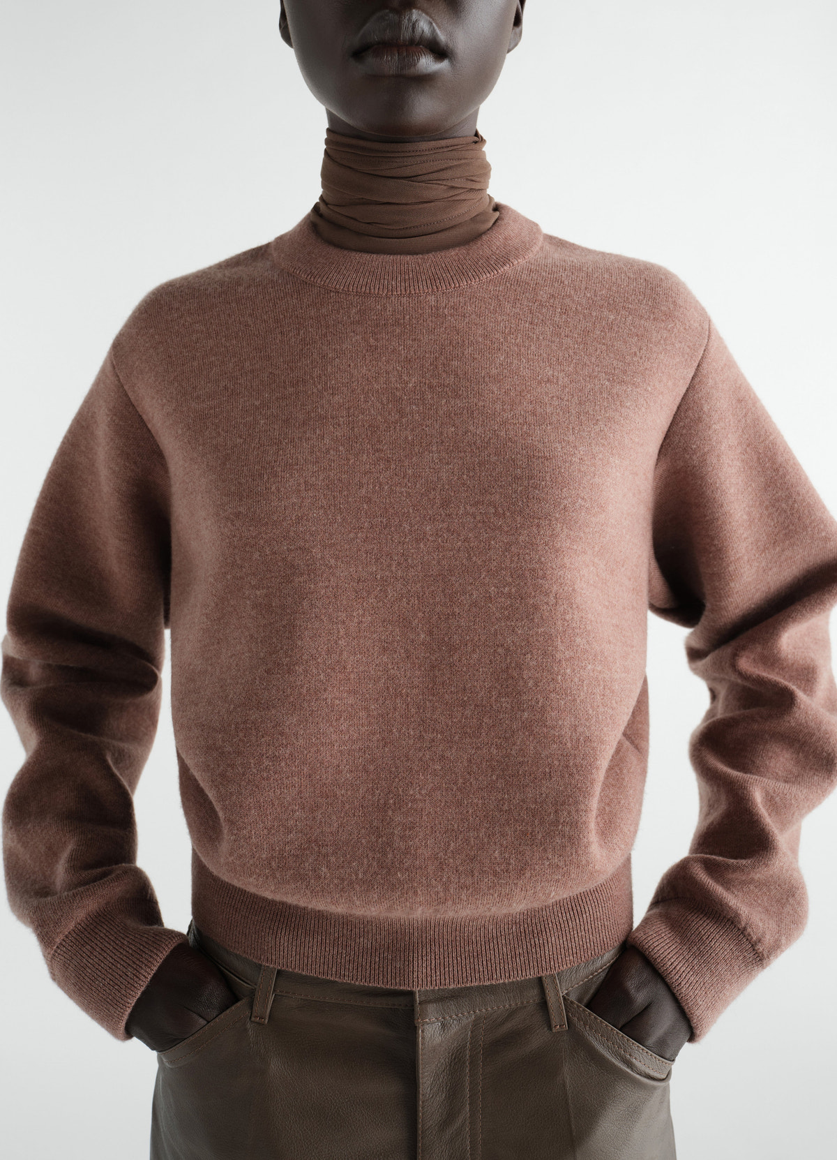 Pull court en laine mérinos feutrée, coloris marron, porté par un mannequin, gros plan de face, poches visibles