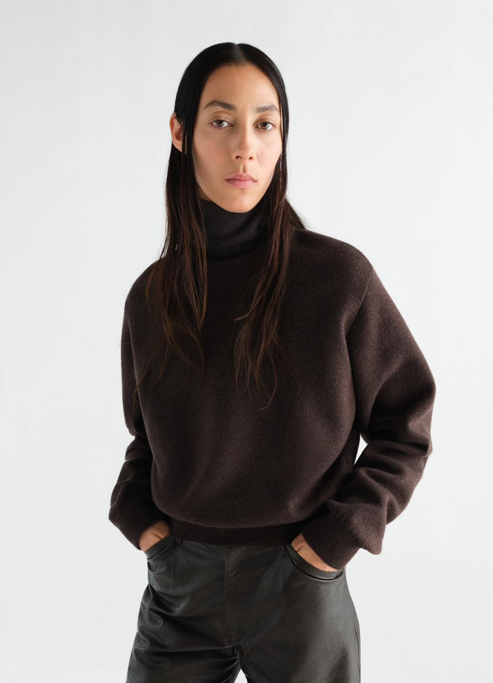 Short dark brown felted merino wool turtleneck sweater by LEMAIRE worn by a model front view