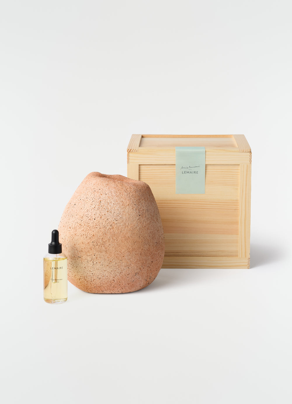 Annie Fourmanoir Pomme L terracotta vase with light wood box and LEMAIRE glass dropper bottle plain white background