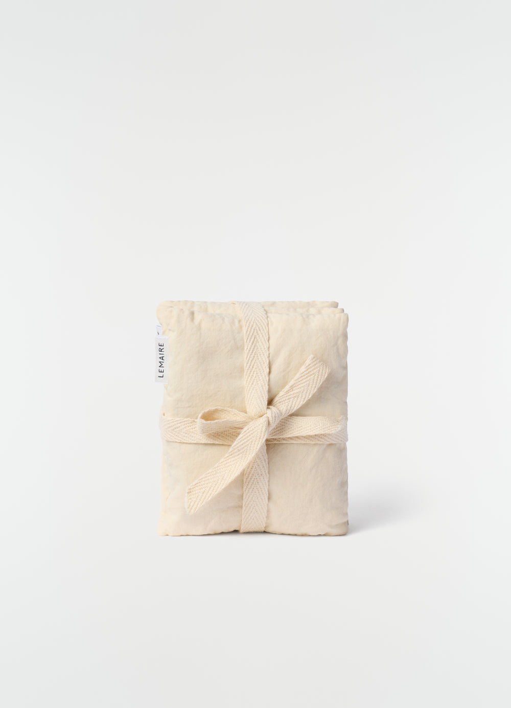 Lavender cushion XS LEMAIRE in natural cotton with tied fabric ribbon on plain white background