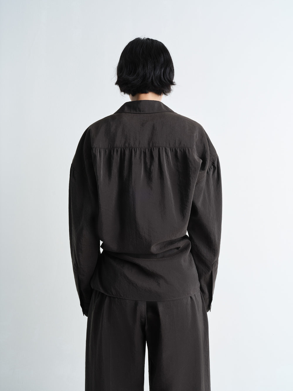 Lemaire Twisted Shirt in Dark Dry Silk, model shot, back view straight collar, loose fit