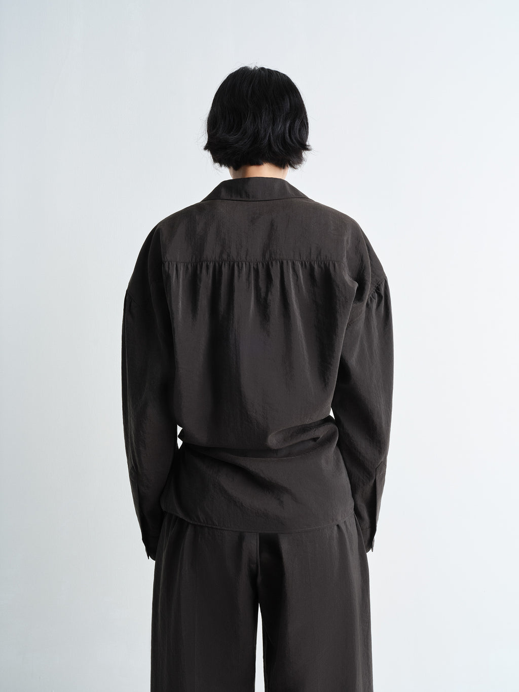 Lemaire Twisted Shirt in Dark Dry Silk, model shot, back view straight collar, loose fit
