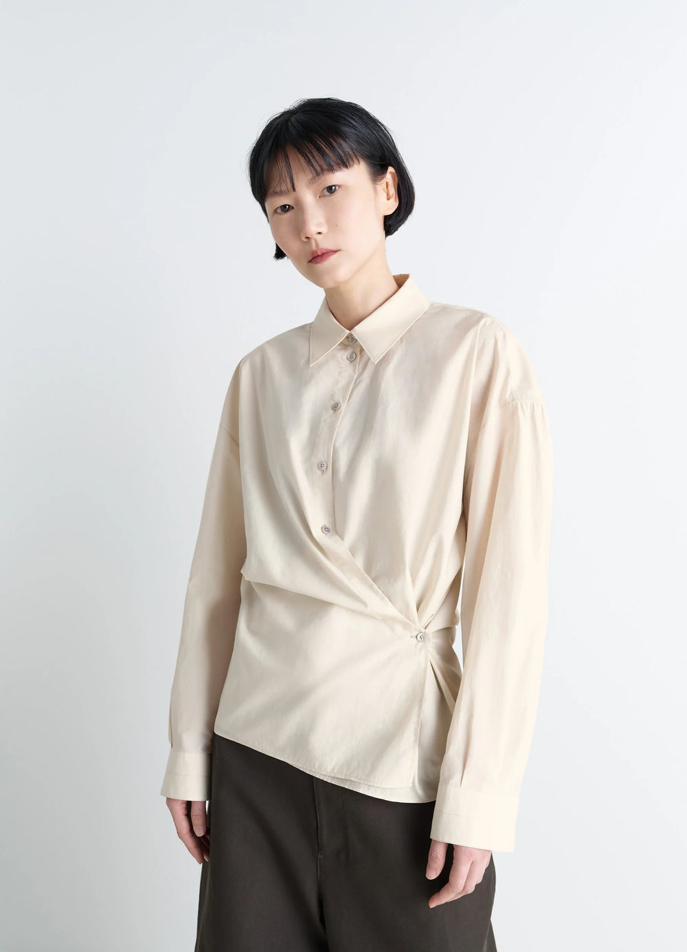 Lemaire Straight Collar Twisted Shi in Cream Washed Cotton-Silk, model shot, front view twisted waist detail