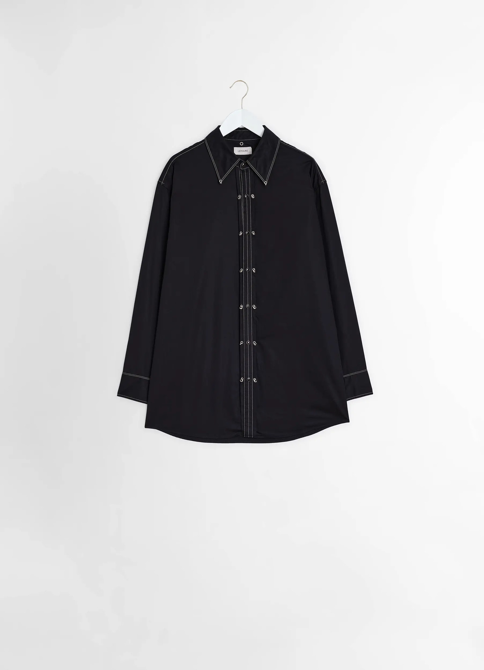 Embellished metal shirt in black cotton satin, product shot, hanging front view hanging on a hanger, curved hem