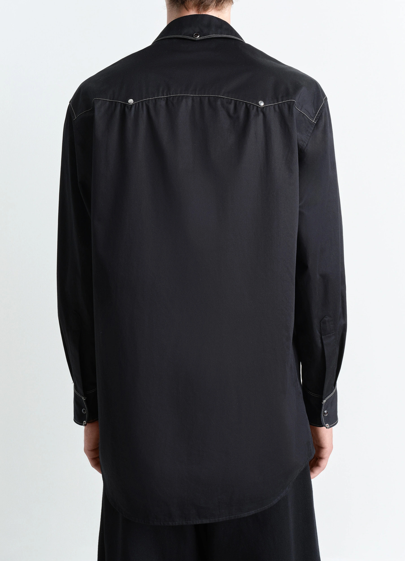 Embellished metal shirt in black cotton satin, model shot, back view curved hem, relaxed fit