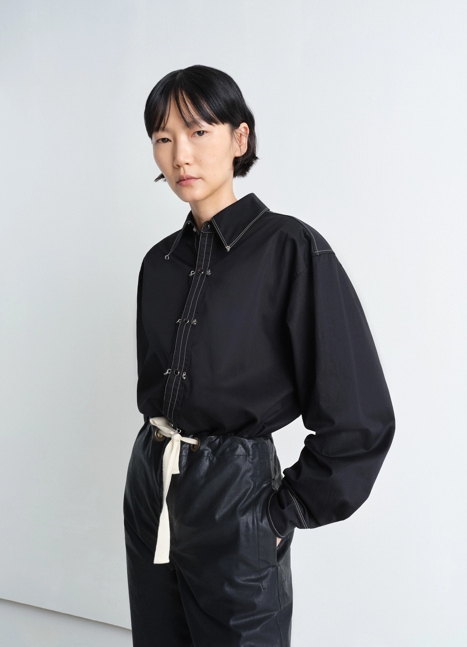 Embellished metal shirt in black cotton satin, model shot, close-up view contrast stitching, oversized fit