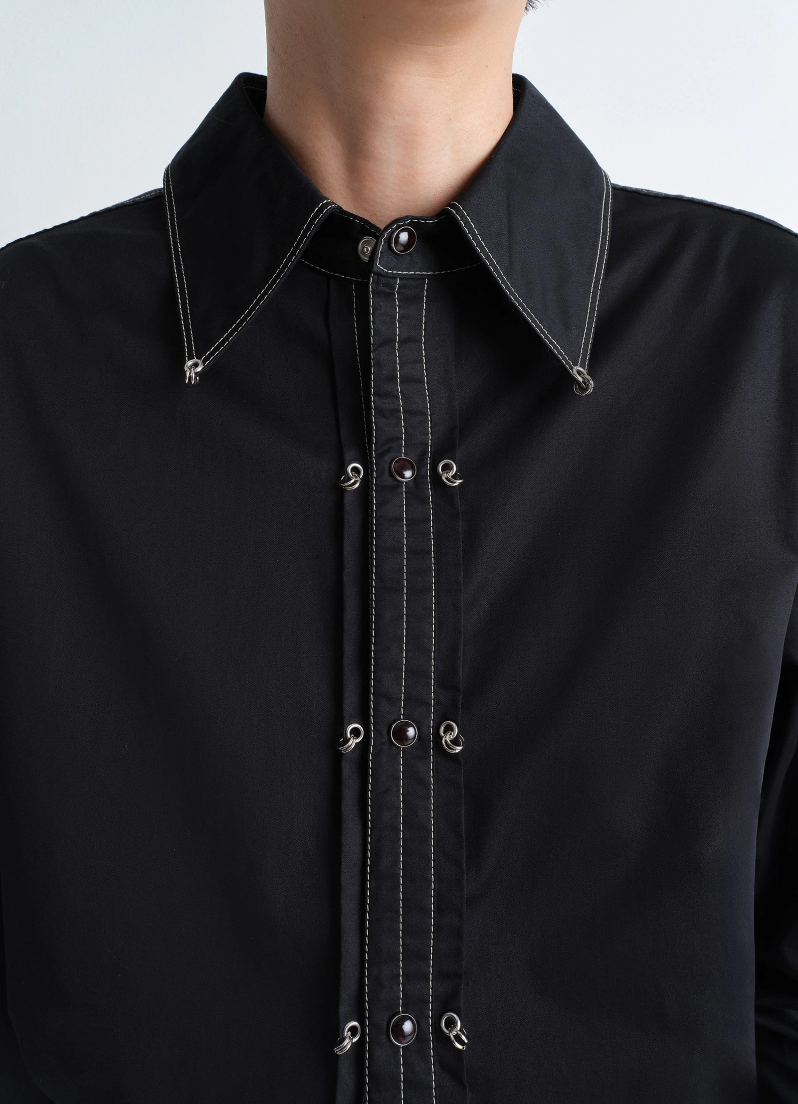 Embellished metal shirt in black cotton satin, model shot, neckline detail shot decorative fastenings visible