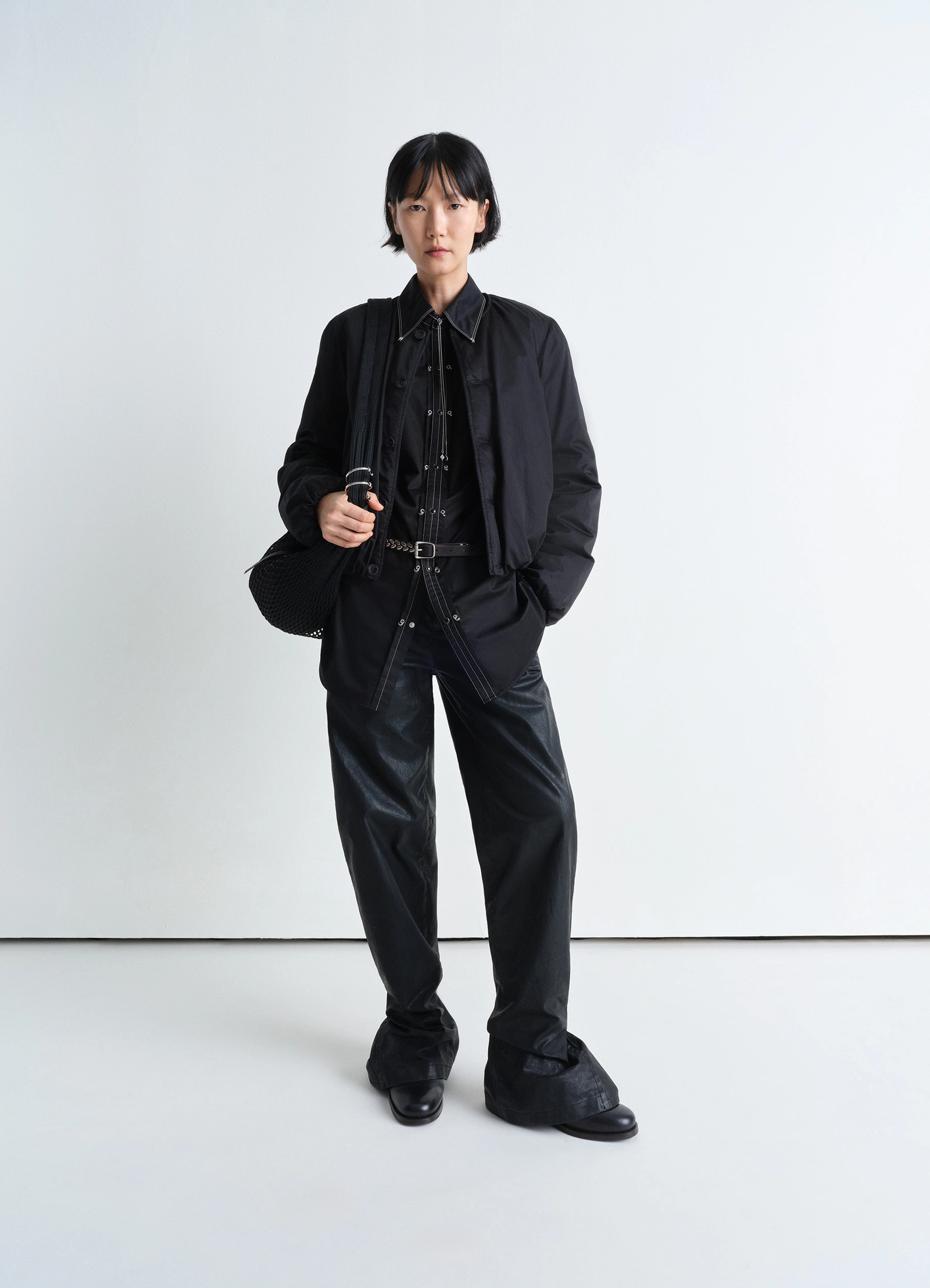Embellished metal shirt in black cotton satin, model shot, mid-length body shot layered with bomber jacket