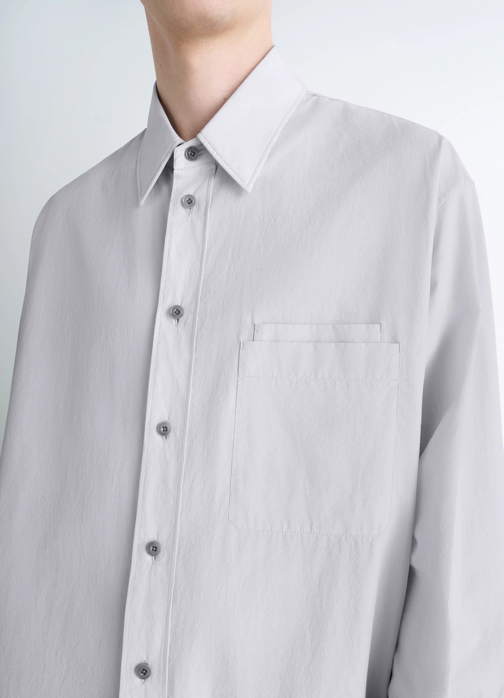 Lemaire Double Pocket Shirt in Light Gray Cotton Crepe, model shot, close-up front detail buttoned placket, pocket detail