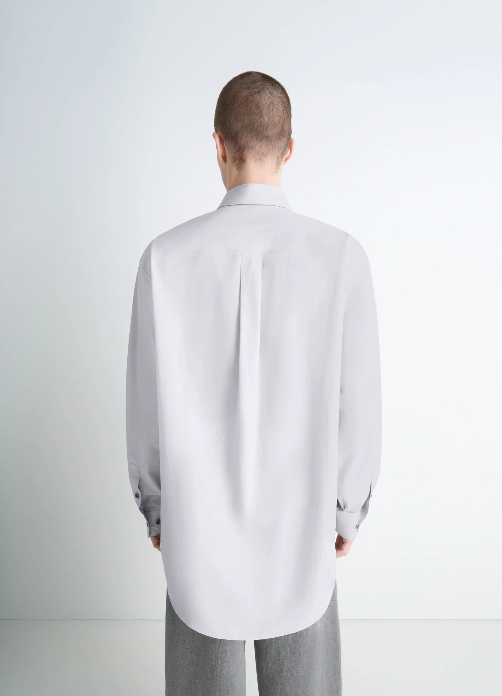 Lemaire double pocket shirt in light gray cotton crepe, model shot, back view soft drape, pleat detail