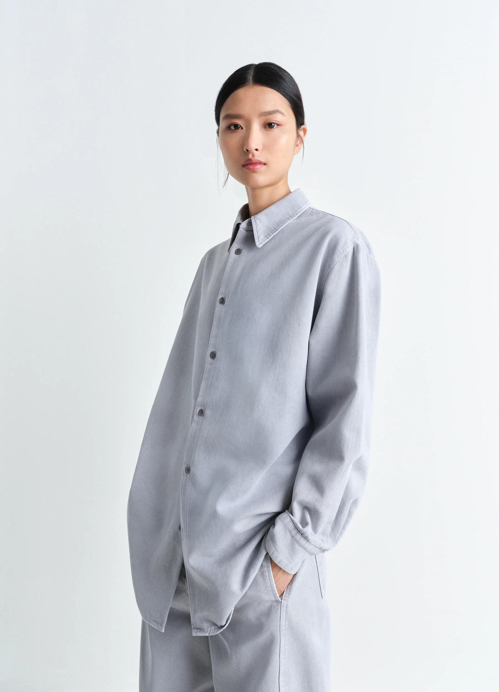 Lemaire relaxed shirt in garment dyed snow denim, model shot, three-quarter view relaxed fit, dropped shoulder