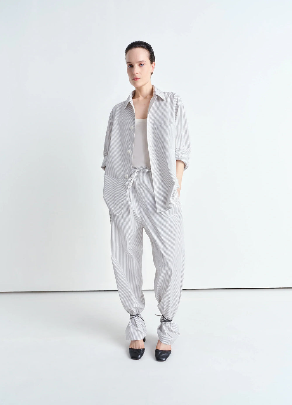 Lemaire Pyjama Shirt in Striped Cotton Poplin, model shot, waist-up front view rolled sleeves untucked