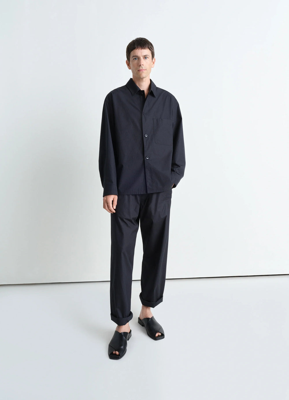 Lemaire Pyjama Shirt in Black Heavy Cotton Washed Poplin, model shot, standing side view loose fit, side pocket visible
