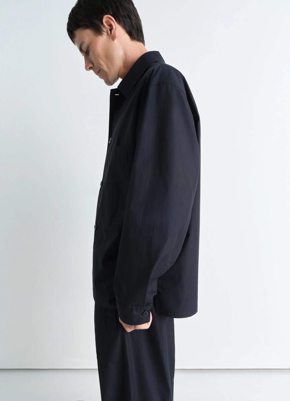 Lemaire Pyjama Shirt in Black Heavy Cotton Washed Poplin, model shot, profile side view elbow-length sleeves