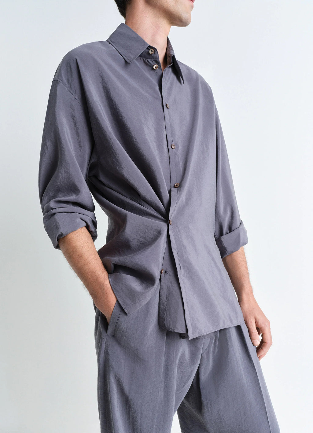 Lemaire Twisted Shirt in Dry Silk, model shot, close-up side view rolled sleeves twist detail