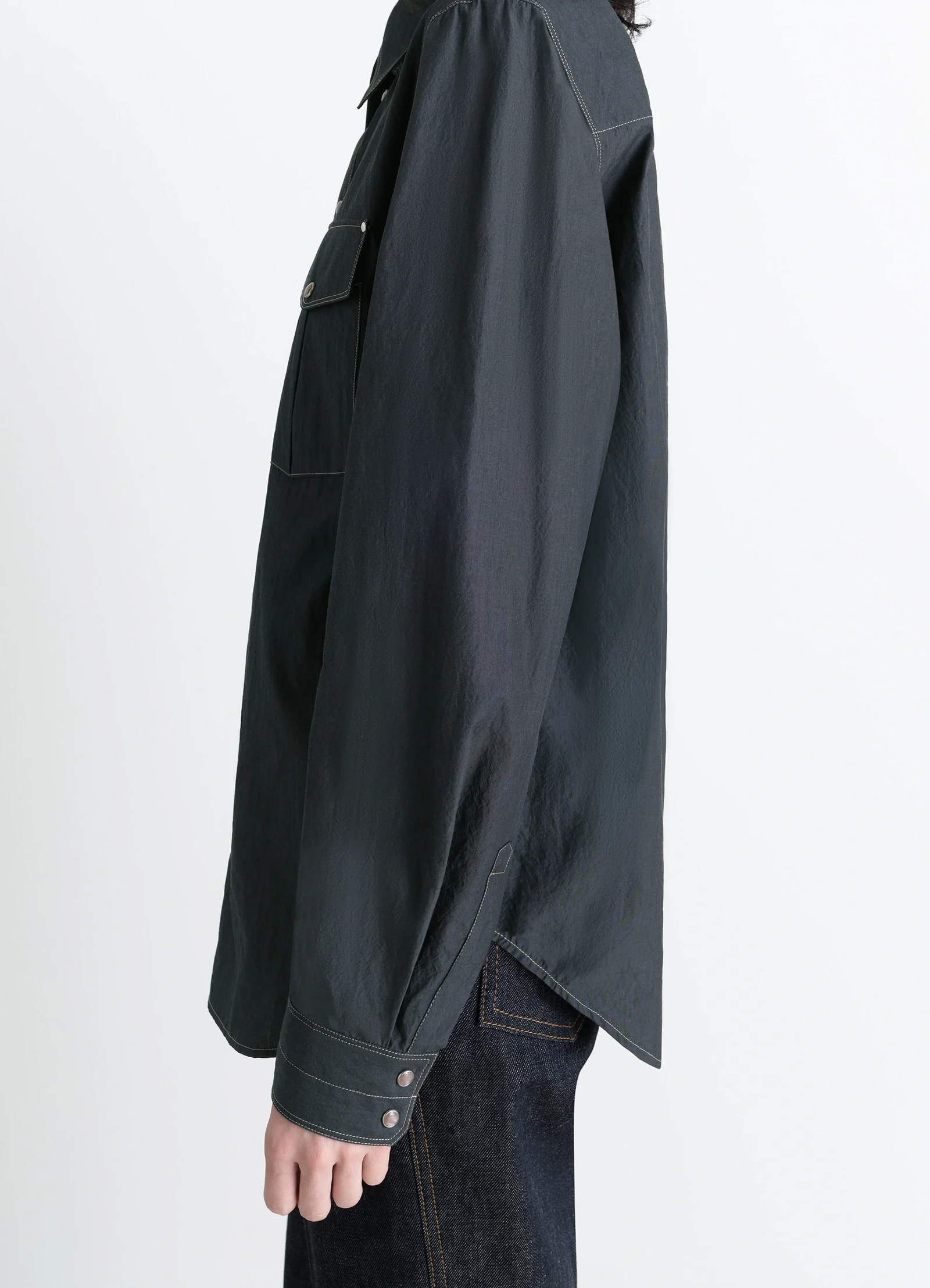 Chest-pocket fitted shirt in dark cotton crepe, model shot, side view angled hem, double cuffs