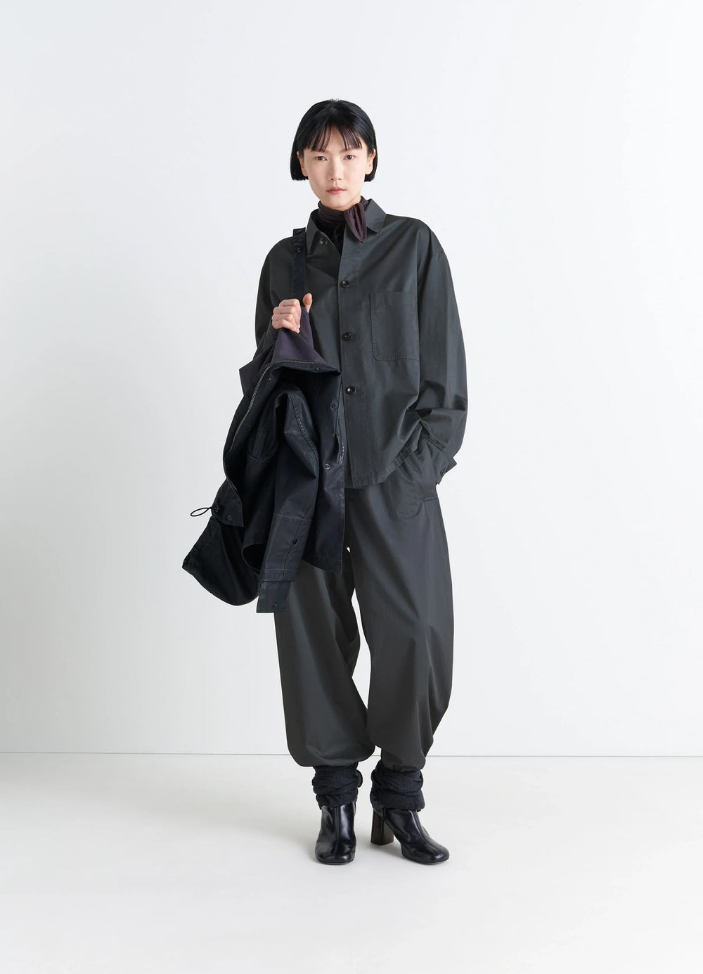 Lemaire Pyjama Shirt in Black Satin Finish Cotton, model shot, three-quarter view buttoned collar, loose fit