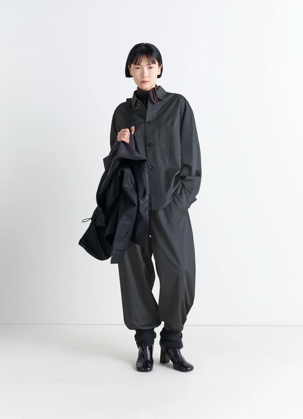 Lemaire Pyjama Shirt in Black Satin Finish Cotton, model shot, three-quarter view buttoned collar, loose fit