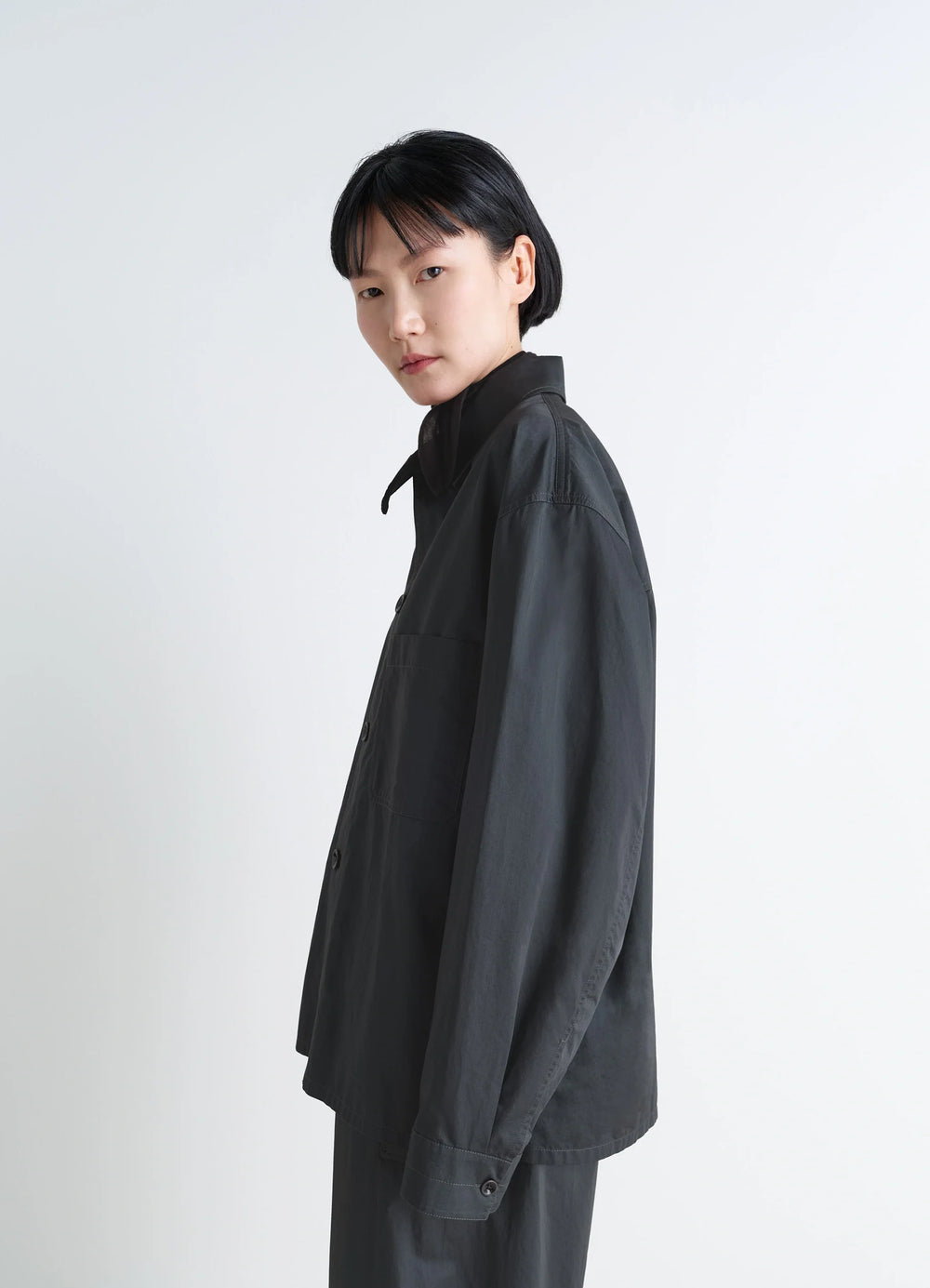 Lemaire Pyjama Shirt in Black Satin Finish Cotton, model shot, side view dropped shoulder