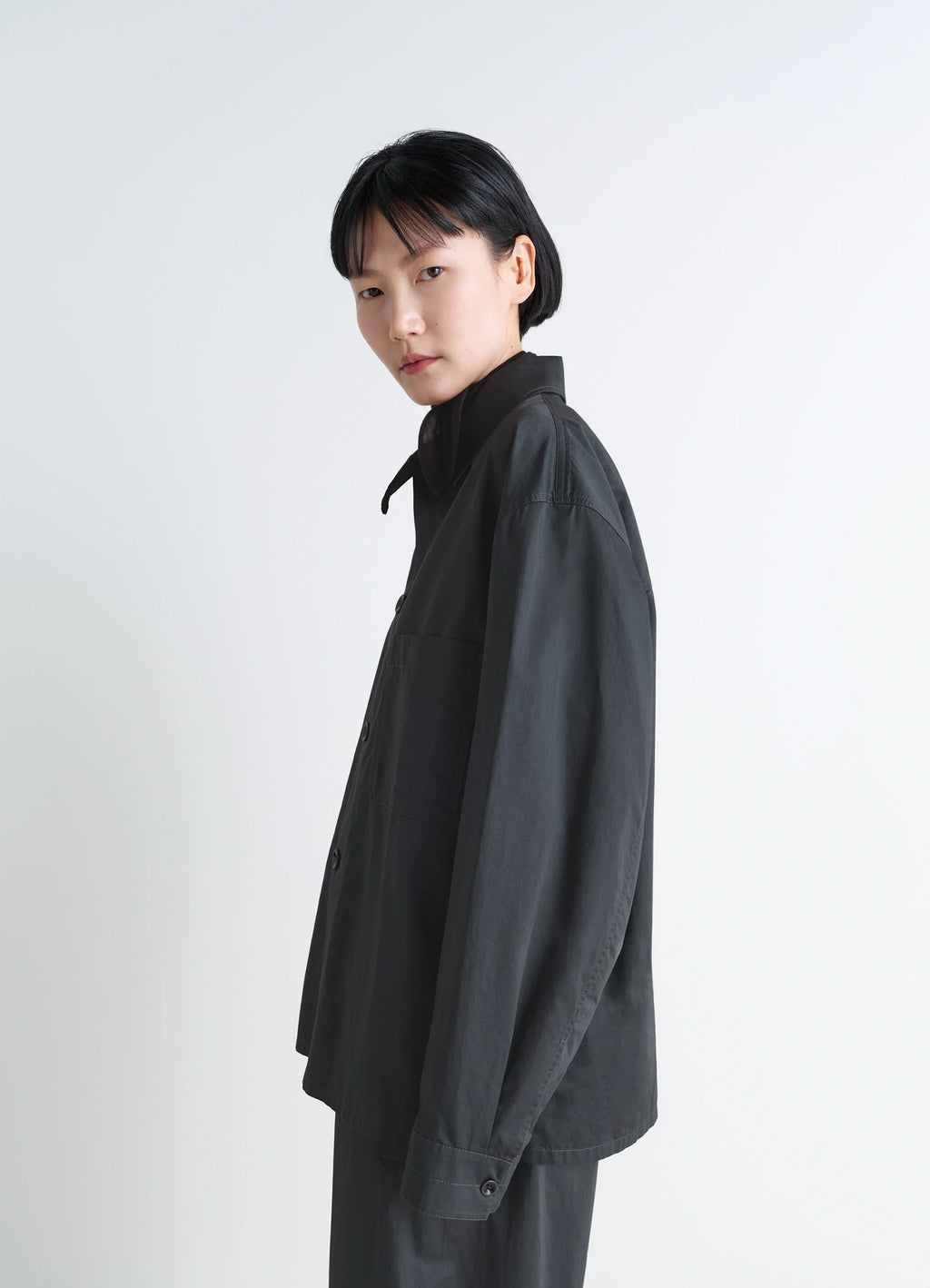 Lemaire Pyjama Shirt in Black Satin Finish Cotton, model shot, side view dropped shoulder
