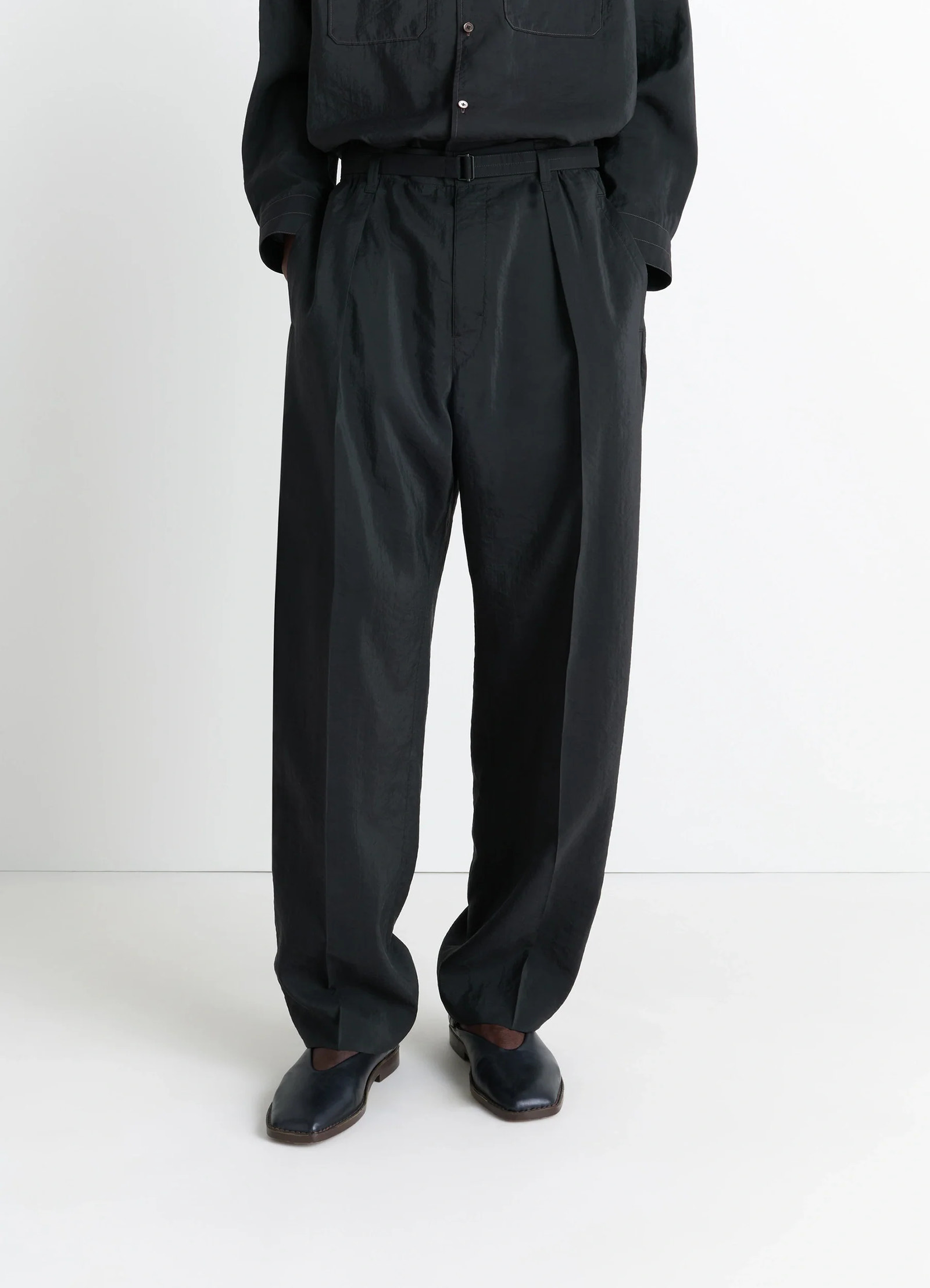 Lemaire convertible collar shirt in black dry silk blend, model shot, waist down detail tucked in, pleated pants