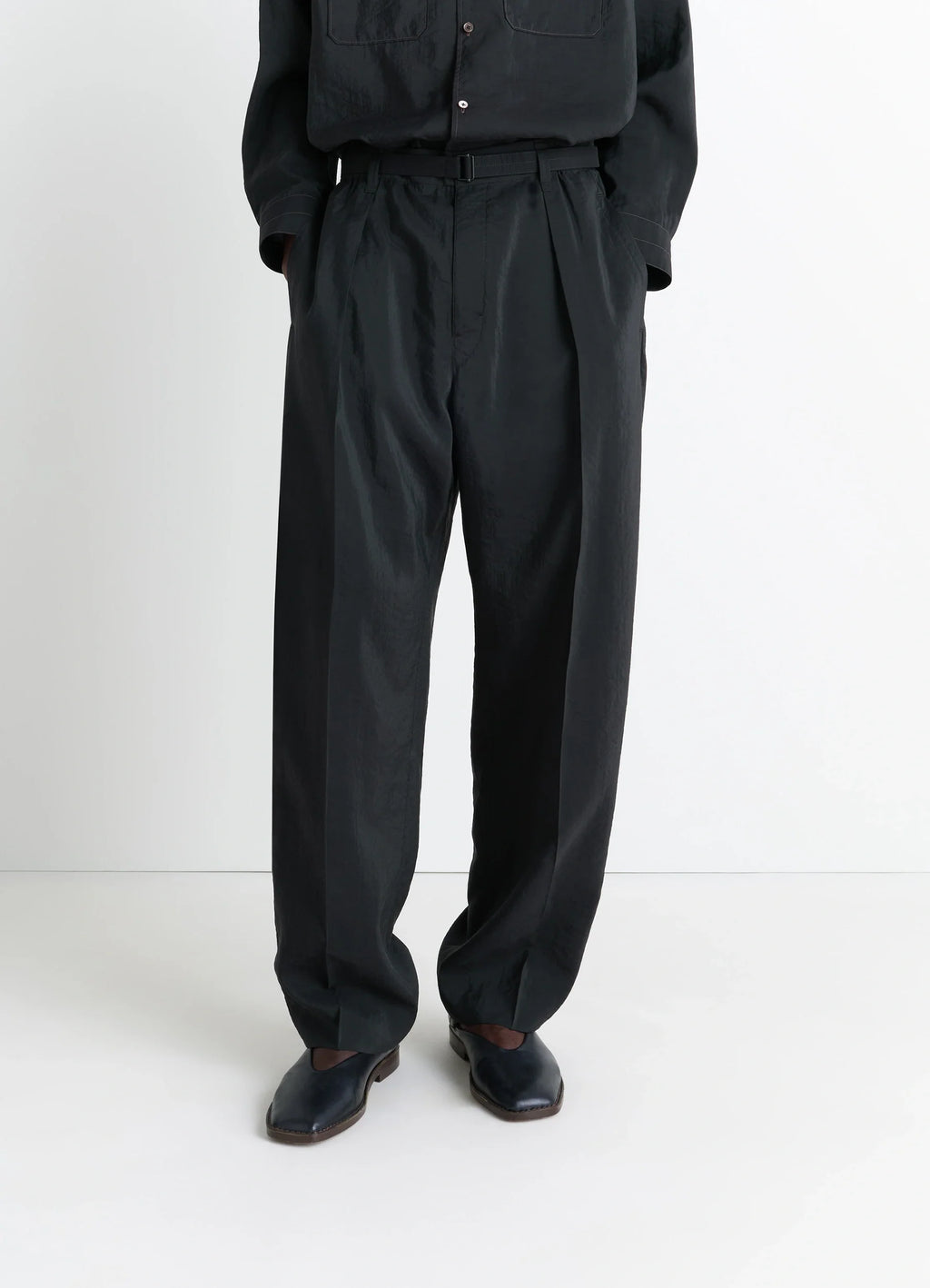Lemaire Convertible Collar Shirt in Black Dry Silk Blend, model shot, waist down detail tucked in, pleated pants
