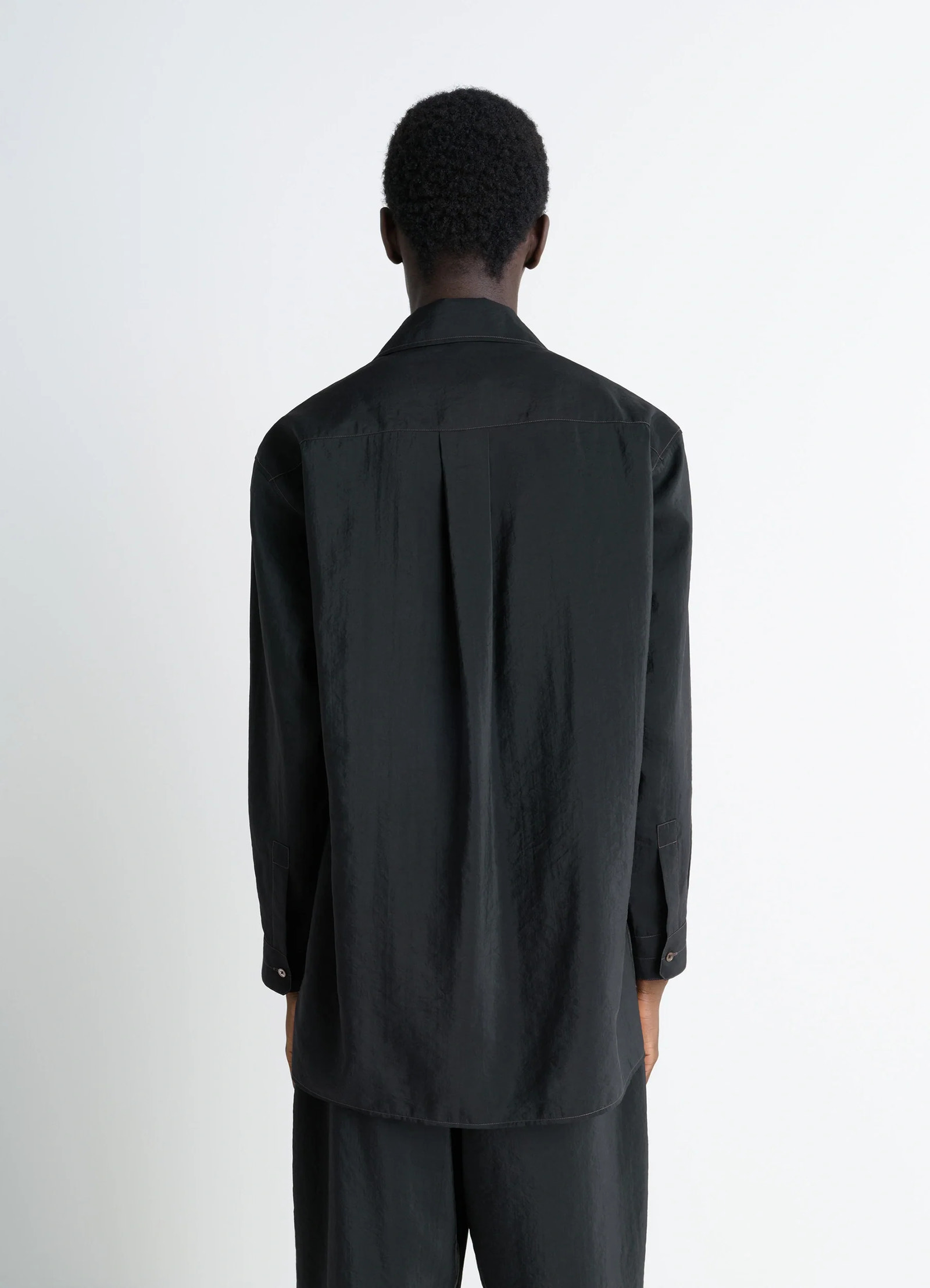 Lemaire convertible collar shirt in black dry silk blend, model shot, back view box pleat back yoke