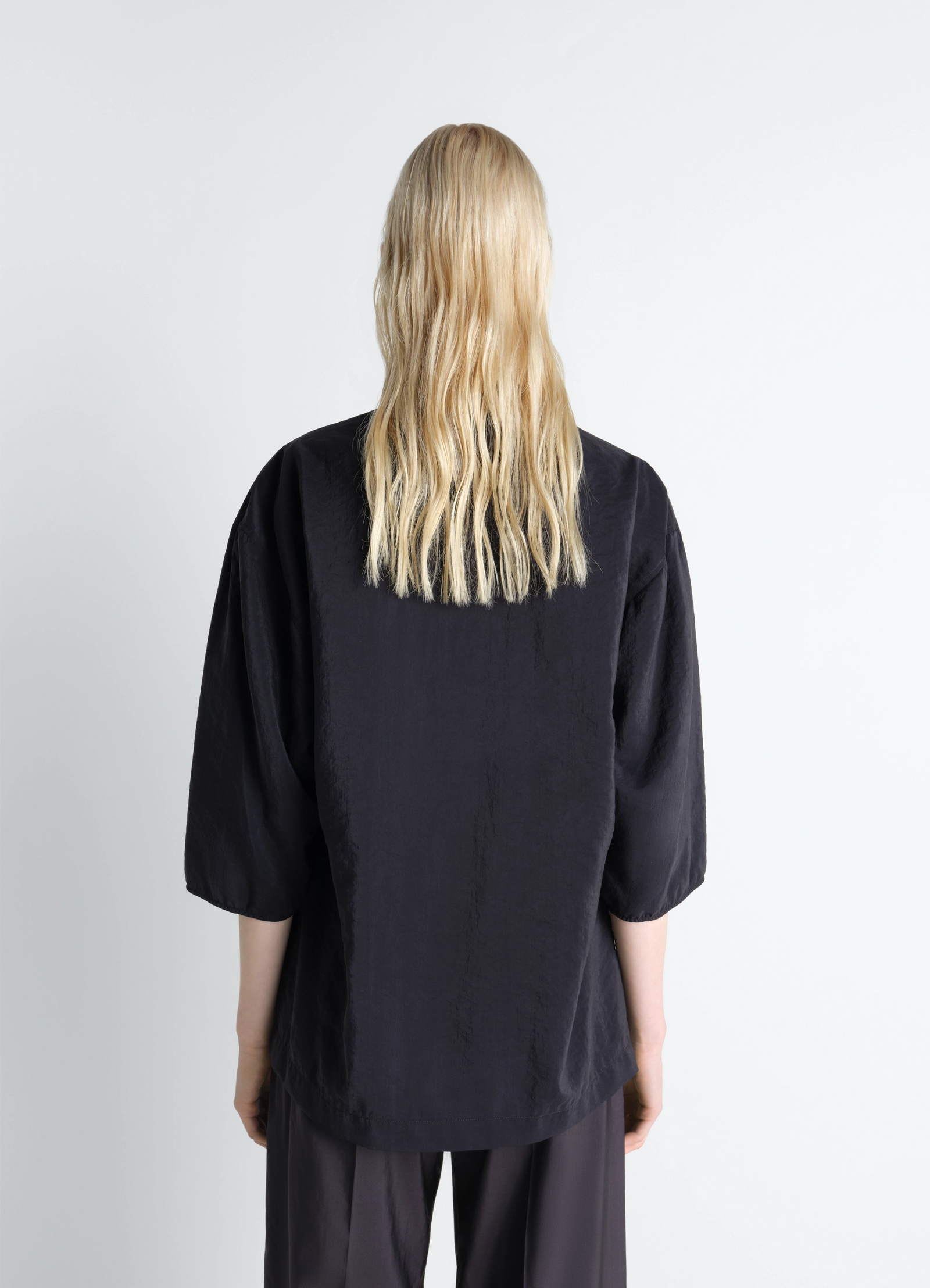 Soft collar top in dry silk in black dry silk, model shot, back view flowy fabric texture