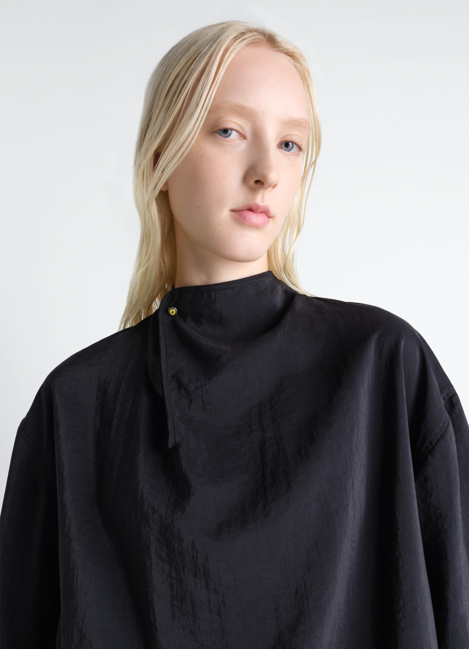 Soft collar top in dry silk in black dry silk, model shot, close-up view high collar design